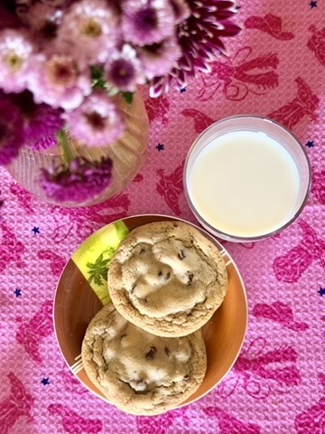 Chocolate chip cookies served with milk and fresh flowers