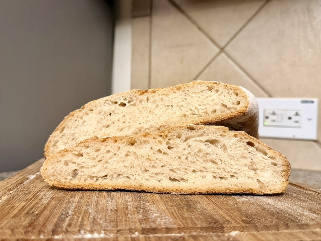 Cut artisan sourdough loaf showing its soft open crumb