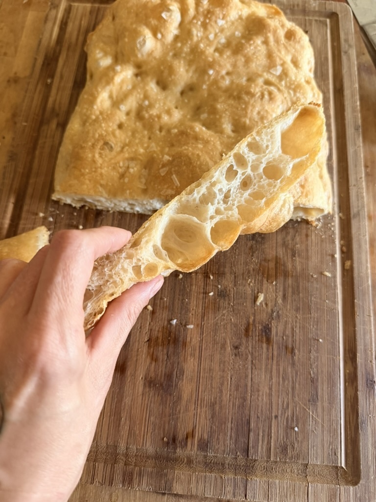 A slice of focaccia showing its light airy crumb